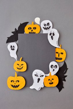 Yaratıcı uygulama korkunç ruhlar gülümseyen Elişi ve gri bir arka plan üzerinde pumpkins, siyah yarasalar gülüyor alanı kopyalayın. Cadılar Bayramı kavramı. Düz yatıyordu.