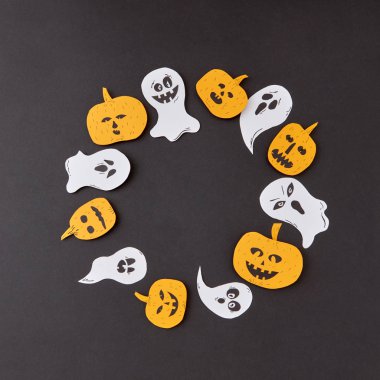 El yapımı gülen uçan hayaletler, ruhlar, siyah bir arka plan, metin için yer korkunç kabaklar ile renkli kağıt yuvarlak yaratıcı çerçeve. Cadılar Bayramı kavramı. Düz yatıyordu.