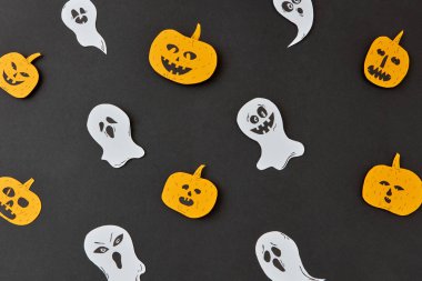 Hareketli hayaletler, ruhlar ve gülümseyen sarı kabak bir siyah Kağıt arka plan üzerinde uçan üzerinden dekoratif Cadılar Bayramı el sanatları desen. Düz yatıyordu.