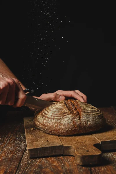 Свіжий Органічний Хліб Дерев Яній Дошці Розрізав Руки Людини Темному — стокове фото