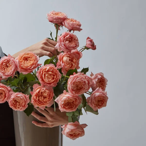 新鮮なバラ 灰色の背景にコピーのテキストのための領域の周りの花瓶にピンクの花と花瓶を保持している女性の手 母の日 — ストック写真