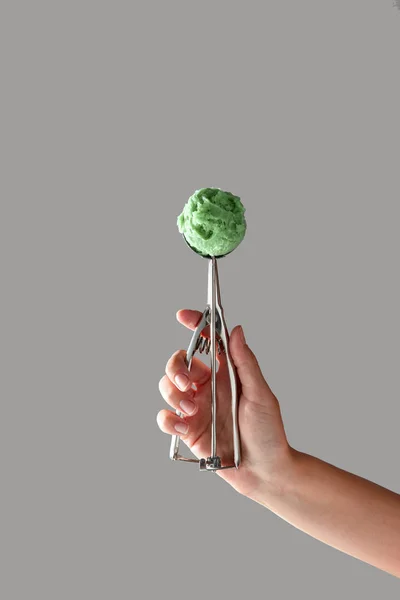 Metal Bir Kaşık Fıstıklı Dondurma Ile Kızın Elini Gri Bir — Stok fotoğraf