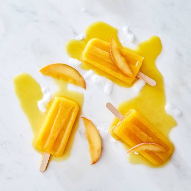 Dondurma lolly Taze şeftali dilimleri ile. Dondurma sıçraması ve buz gri mermer arka plan metin için yer ile adet desen. Düz yatıyordu