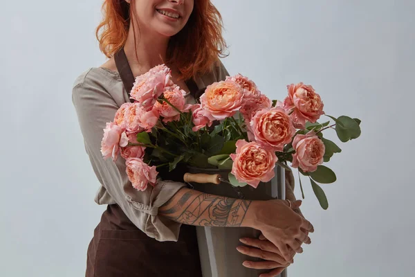 Uśmiechnięte Dziewczyny Brązowy Fartuszek Tatuaż Posiada Piękny Bukiet Róż Wazonie — Zdjęcie stockowe