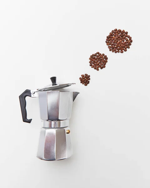 stock image Circles of coffee beans in the form of a steam from a metal coffee maker on a white background copy space. The concept of making morning coffee. Flat lay