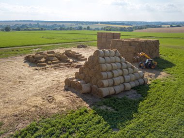 Haystacks etrafında mavi gökyüzü güneşli bir sonbahar tarım makine ile yeşil alan.