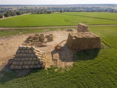 Tarım makineleri traktör mavi gökyüzü güneşli bir karşı bir alana büyük haystacks