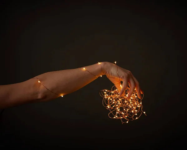 Vrouw Hand Versieren Met Gele Slingers Rond Een Zwarte Achtergrond — Stockfoto