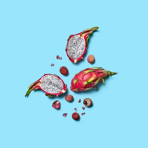 食欲をそそる全体とライチとピタハヤの半分は テキスト用のスペースに青色の背景にフルーツします エキゾチックな健康的な果物 フラットを置く — ストック写真
