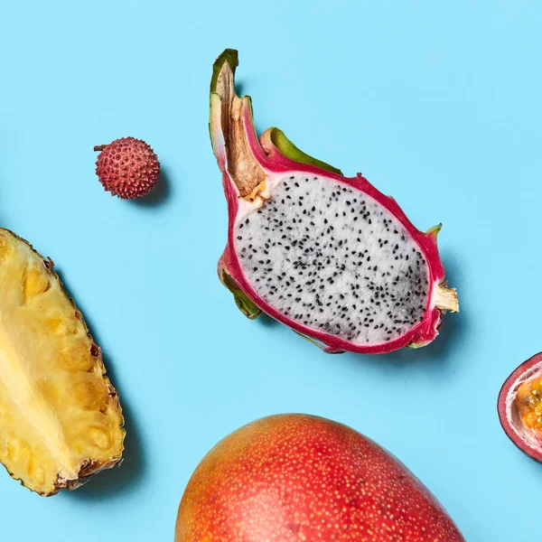 Zbliżenie Owoców Tropikalnych Niebieskim Tle Plasterki Ananas Pitahaya Soczyste Mango — Zdjęcie stockowe