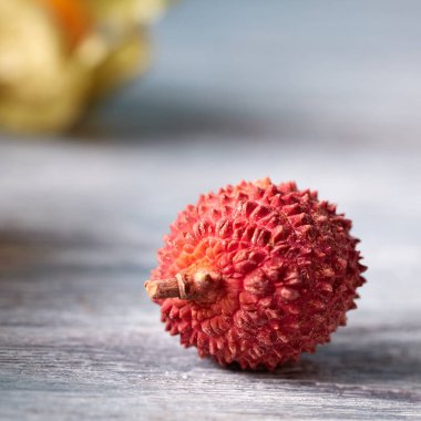 Tropical fresh fruit ripe litchi single on a gray wooden table with place for text. Close-up. clipart