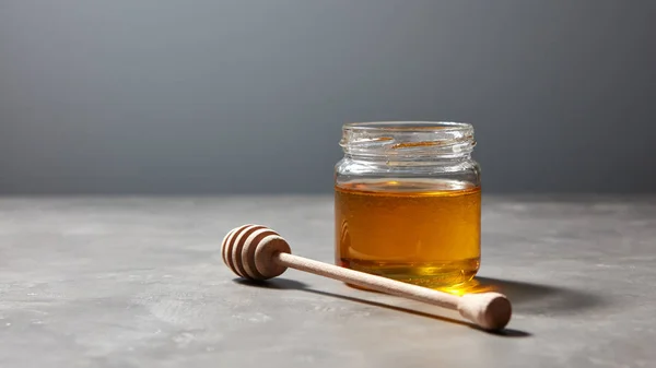 Αρωματικό Φρέσκο Φυσικό Μέλι Κουτάλα Γυάλινο Δοχείο Γκρι Πέτρινο Φόντο — Φωτογραφία Αρχείου