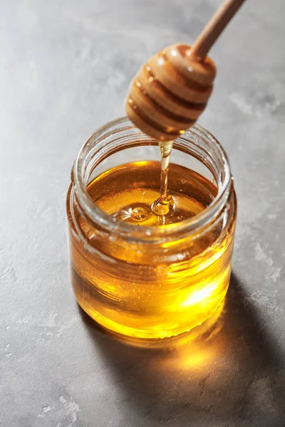 Dripping Sweet Natural Organic Honey Stick Glass Jar Gray Marble — Stock Photo, Image