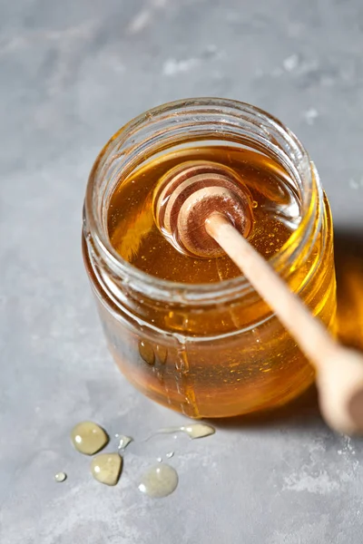 天然の甘い蜂蜜と灰色の石造りの台所の背景にディッパー ガラスポット 本文の下に置きます 伝統的な純粋な自然な甘い善 — ストック写真