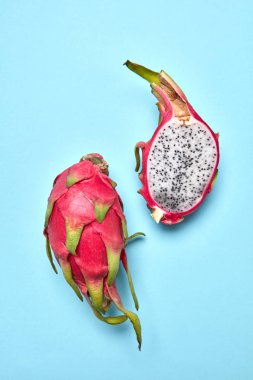 Pitahaya tropik meyve, meyve pastel mavi arka plan, kopya alanı üzerinde iki halfs ile renkli meyve deseni. Üstten görünüm.