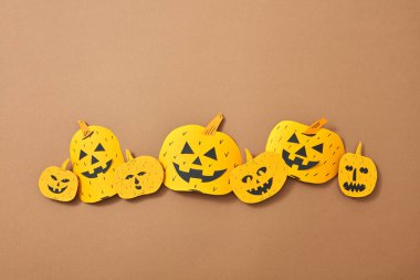 Farklı el sanatları korkunç kabaklar metin için yer kahverengi bir zemin üzerine. Cadılar Bayramı için yaratıcı kompozisyon. Düz yatıyordu