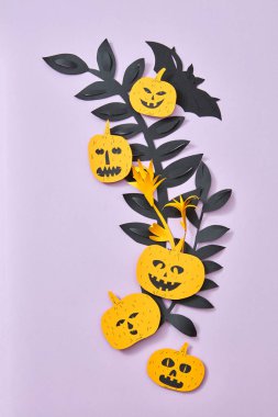 Siyah yaprak, kabaklar korkunç yüzler ve yarasa kopya alanı metin için mor bir zemin üzerine kağıt kompozisyon elişi. Cadılar Bayramı, düz lay