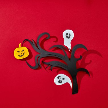 Kağıt şube, korkutucu Kabak ve ghosts yansıması gölgeler ve kopya alanı ile kırmızı bir arka plan üzerinde gülümseyen. Yaratıcı el sanatları Cadılar Bayramı kartı. Düz yatıyordu