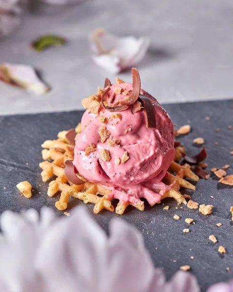 灰色コンクリートのテーブルの上のスレート板のチョコレート チップを搭載したウェーハ上のベリーのアイスクリームのスクープは 花弁の花で飾られました 甘いデザート — ストック写真