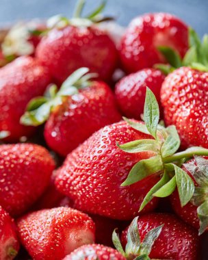 Yeşil yaprakları ile organik çilek kırmızı meyveler closeup. Sağlıklı bir diyet yemek