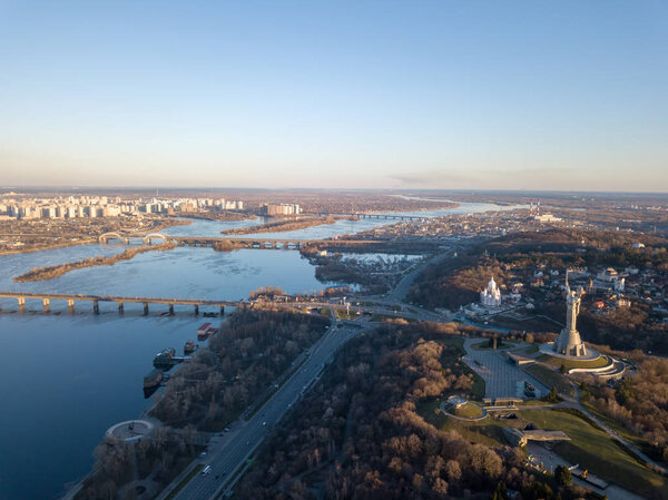 Aerial view from the drone to the Dnieper River with modern architecture, the Motherland Monument, Patona Bridge, Darnytskyy Mist, South Bridge in Kiev, Ukraine.