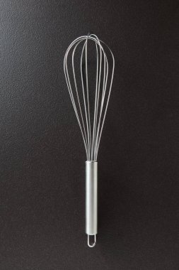 Metin için yer siyah bir beton zemin üzerine sunulan metal çırpma teli... Mutfak aygıt farklı gıdalar yemek için. Üstten görünüm