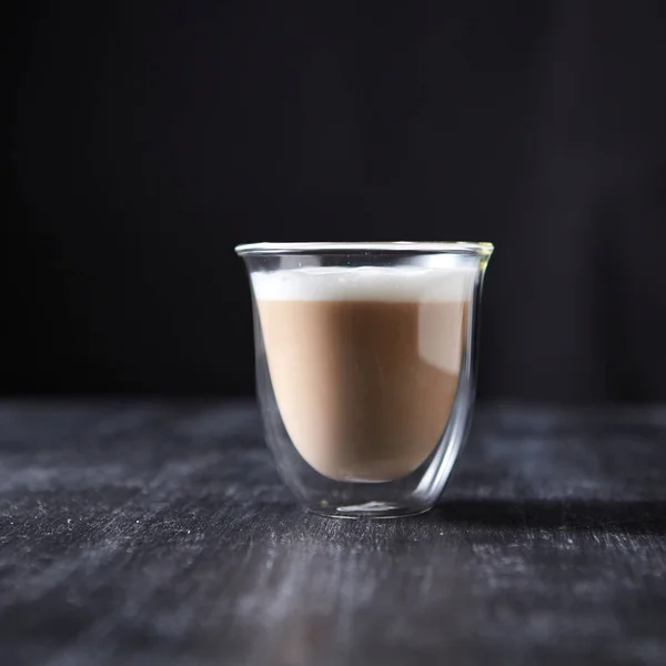 一杯热味卡布奇诺的咖啡杯呈现在一张黑色的木桌上 有复制空间 — 图库照片