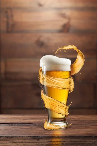 一杯冷啤酒 在有复制空间的深色木制背景上飞溅 — 图库照片