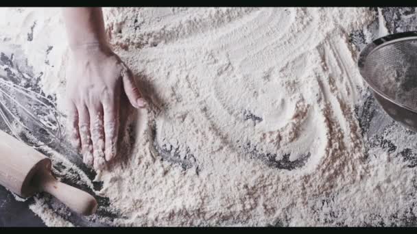 mains féminines préparant la farine sur la table, pétrissant la pâte 