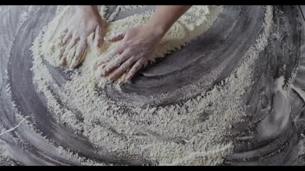 mains féminines préparant la farine sur la table, pétrissant la pâte 