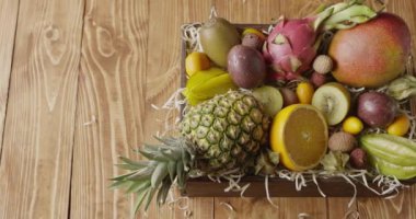 Jucy ahşap arka plan kutusunda taze tropikal meyve. Passion fruit, carambola, mango, Çin, Kamkat, yarım turuncu, phisalis 