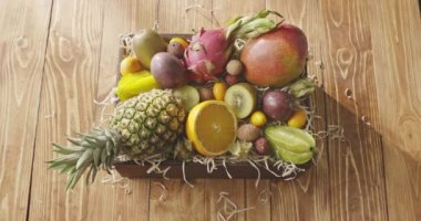 Jucy ahşap arka plan kutusunda taze tropikal meyve. Passion fruit, carambola, mango, Çin, Kamkat, yarım turuncu, phisalis 