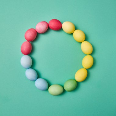 Renkli yumurta kopya alanı ile yeşil bir arka plan üzerinde yuvarlak bir kare şeklinde. Kartpostal için yaratıcı Paskalya düzen. Düz yatıyordu