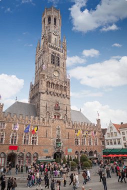Bruges, Belçika - 17 Mayıs 2012: Arka plan olarak Belfort ile Markt yerde sokak müzisyenleri zevk insan grupları