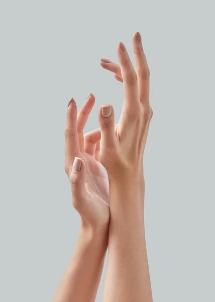 灰色の背景に爪にマニキュアを光で美しい女性の手のイメージを閉じます 皮膚のケア 手のマニキュア ビューティートリートメント テキストのための場所 — ストック写真