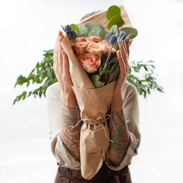 Frauenhände Mit Tätowierung Halten Einen Blumenstrauß Lebender Korallenrosen Und Grüner — Stockfoto