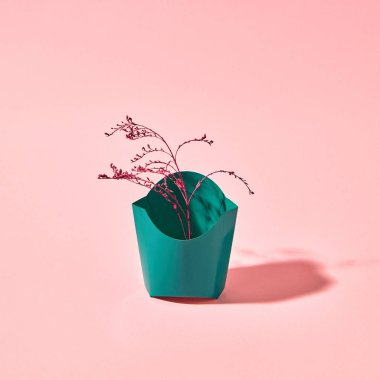 Kopya alanı ile pembe bir arka planda sunulan bir karton yeşil kutuda kırmızı boyalı şube. Kartpostal