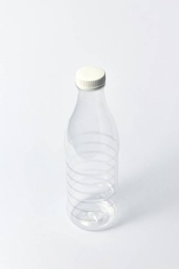 Süt ürünleri için plastik şeffaf boş şişe, su ve açık gri arka plan üzerinde beyaz fincan ile diğer sıvı, alay. Kopyalama alanı.