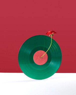 Metin için alan ile çift kırmızı beyaz arka plan üzerinde bir çiçek ile süslenmiş yeşil retro vinil kayıt