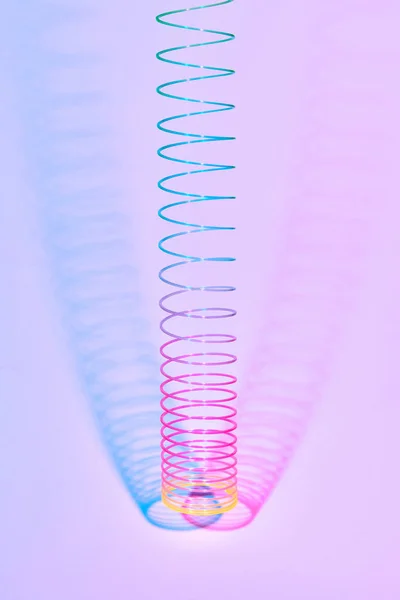 Голодная Разноцветная Пластиковая Спиральная Игрушка Двумя Двойными Тенями Пастельно Розовом — стоковое фото