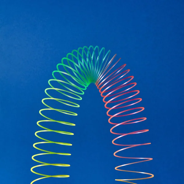 Stratching Espiral Brinquedo Colorido Forma Parábola Fundo Azul Com Espaço — Fotografia de Stock