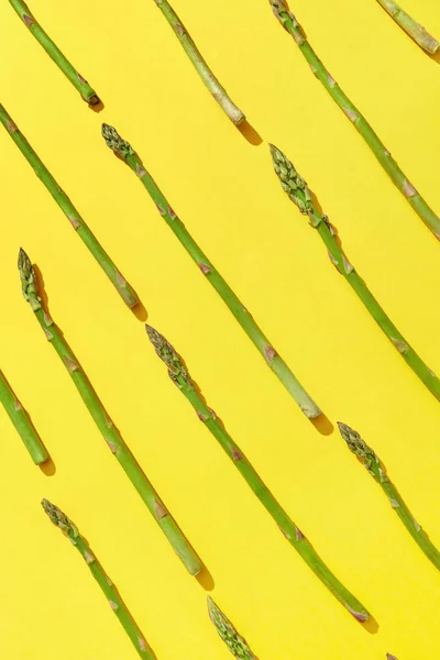 Padrão Diagonal Espargos Verdes Naturais Recém Colhidos Fundo Amarelo Com — Fotografia de Stock