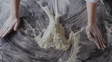 Kadın elleri masada un hazırlıyor, hamur yoğuruyor.