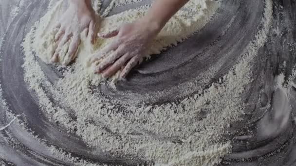 mains féminines préparant la farine sur la table, pétrissant la pâte 