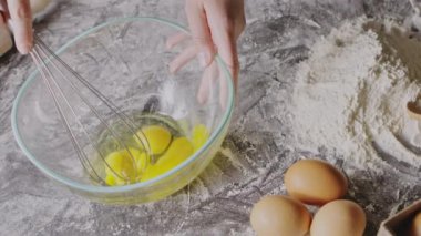 Kadın çırpılmış yumurta sarısı çırpıyor, hamur yoğurmaya hazırlanıyor.