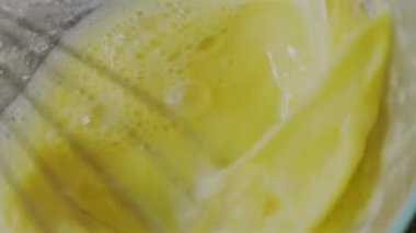 Kadın çırpılmış yumurta sarısı çırpıyor, hamur yoğurmaya hazırlanıyor.