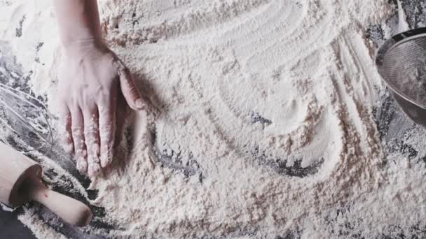 mains féminines préparant la farine sur la table, pétrissant la pâte 