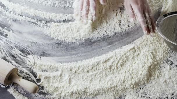 mains féminines préparant la farine sur la table, pétrissant la pâte 