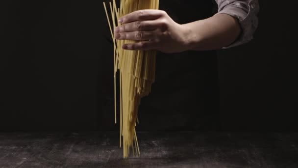 黑黑的背景 意大利食物的概念 手里拿着一堆意大利面 — 图库视频影像