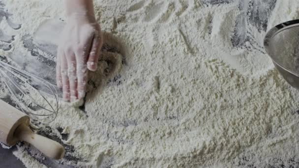 mains féminines préparant la farine sur la table, pétrissant la pâte 